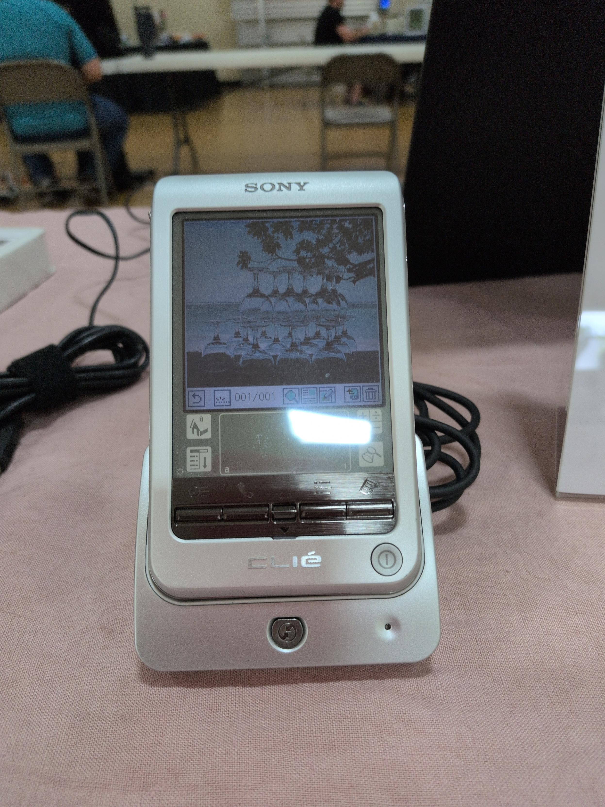 A Sony CLIÉ PEG-T615 with the same picture of clear stacked glasses, but in color instead of 4-bit grayscale.