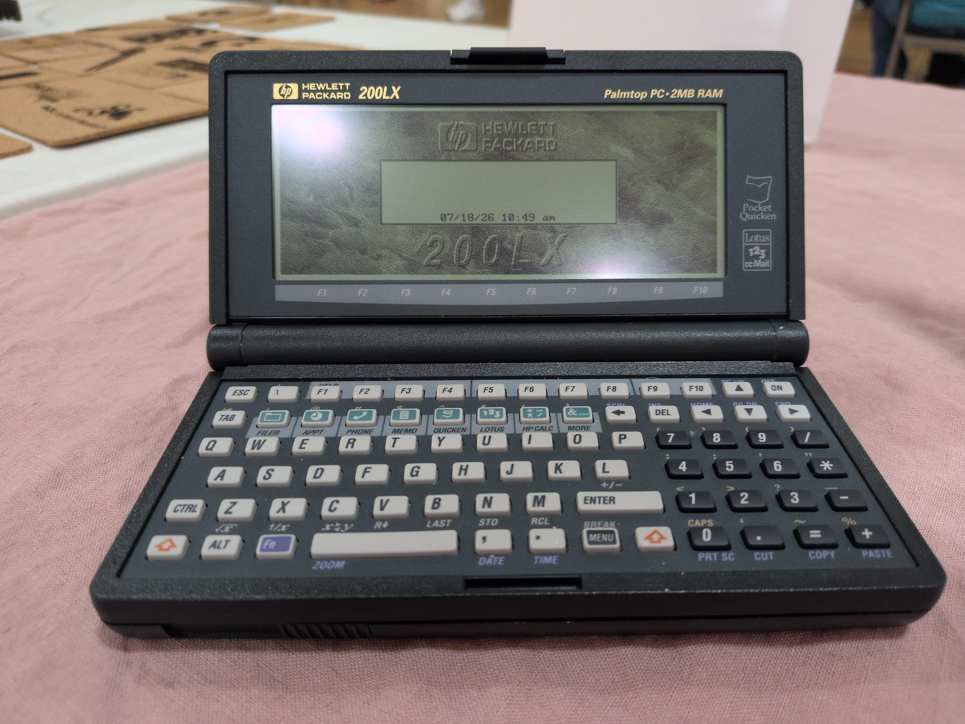 A closeup of the HP 200 LX, showing the screen and keyboard, on its home screen after booting