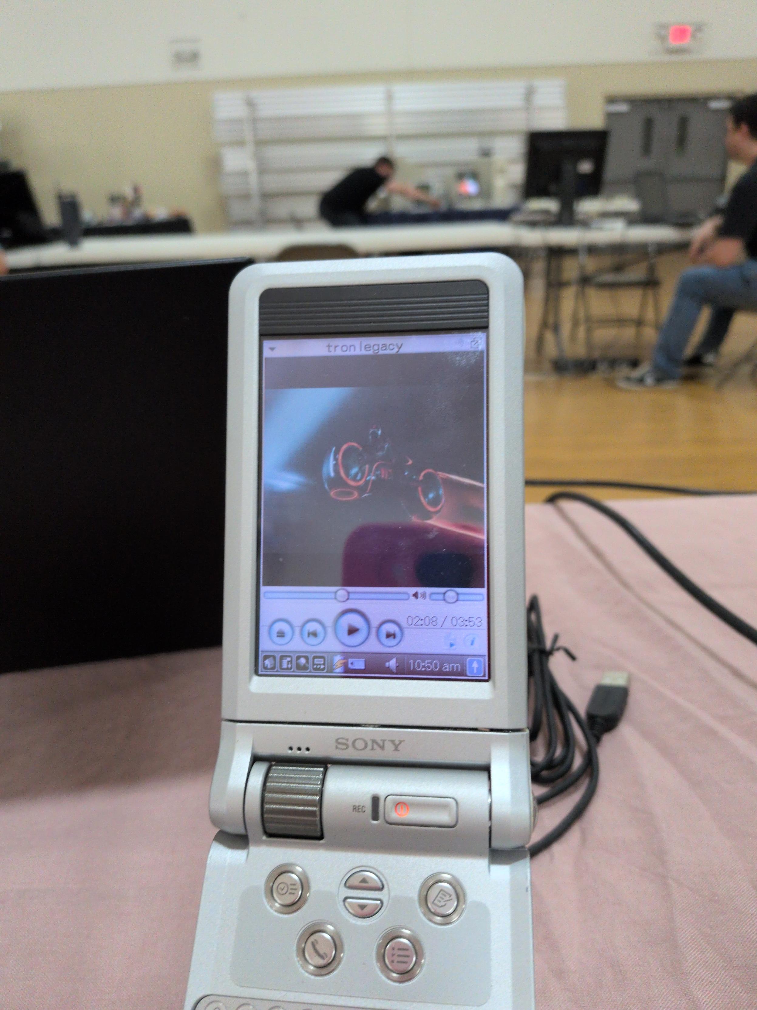 A Sony CLIÉ PEG-NX70V halfway through playing a scene from "Tron Legacy"
